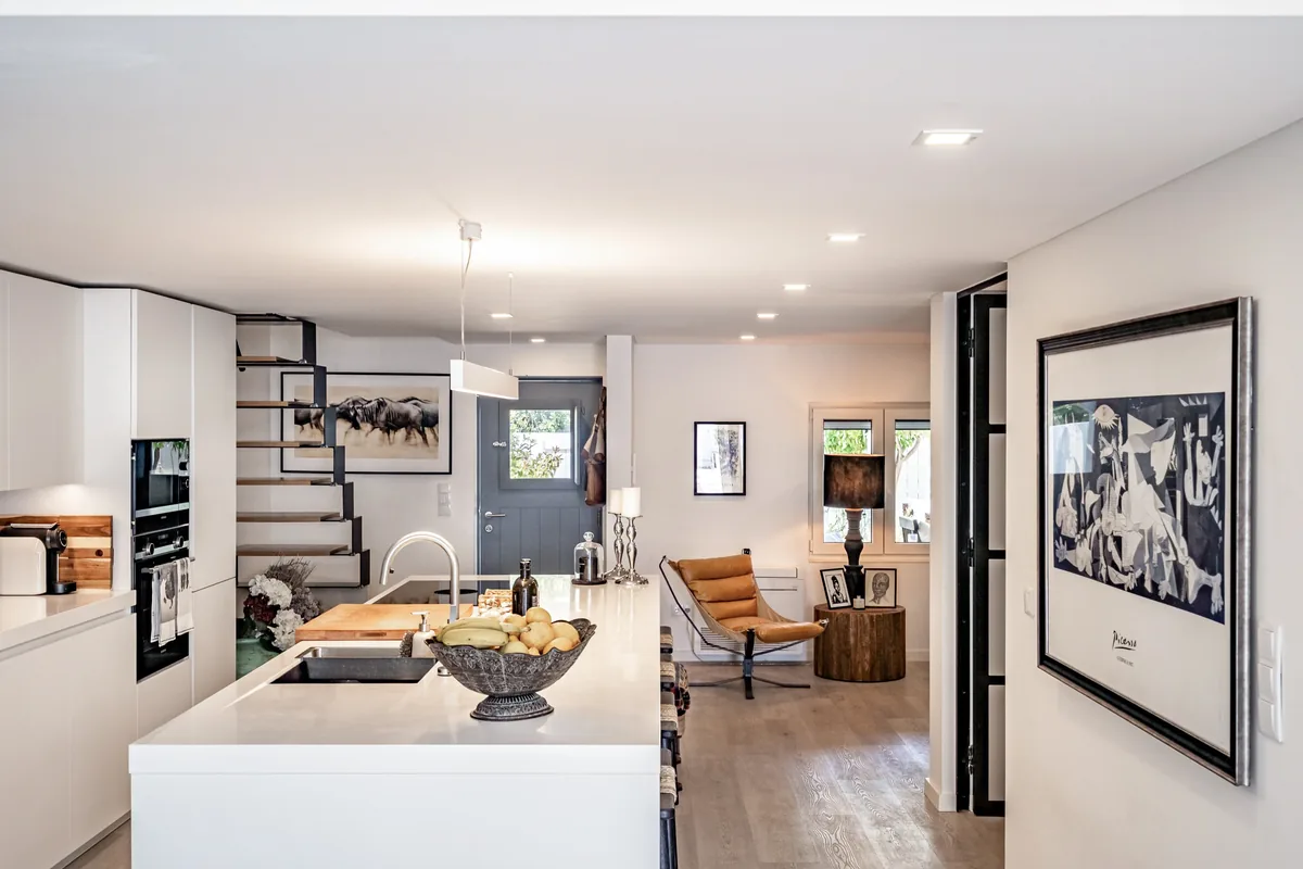 Open-plan kitchen and living room with floating staircase at Comporta Village House